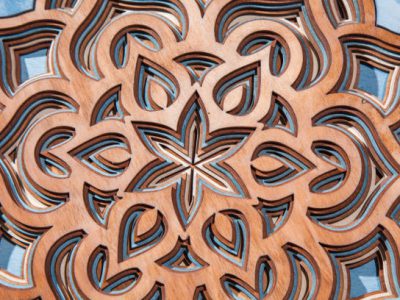 The layers of the mandala are cut from a tree by a laser The layers of the mandala are cut from a tree by a laser